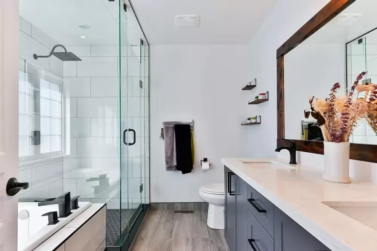 a glass shower door and a white ceramic sink