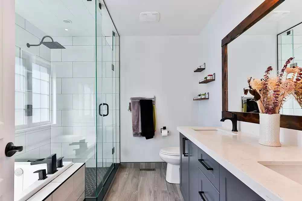 a frameless bifold shower door and glass shower inside a chic, modern bathroom